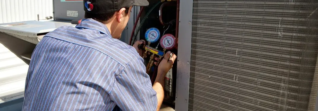 HVAC technician servicing a condenser unit in Lakeland