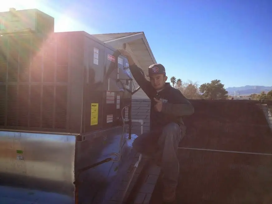 HVAC technician performing AC Tune-Up on a rooftop unit in Lakeland